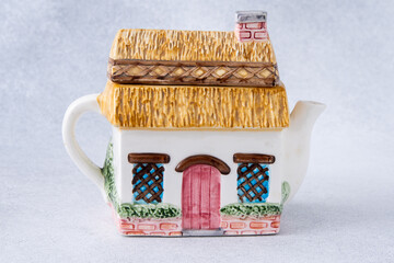 Old kettle in the shape of a house. Antique porcelain tea pot
