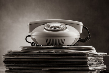 Old rotary phone on a stack of records. The concept of music and phone in one place. Vintage vinyl...