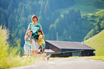Grandmother and children in Switzerland Alps on a sunny summer day