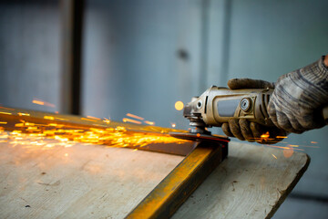 Grinding machine at work. Sparks fly from under the grinders, men's work. Dark background with copy...