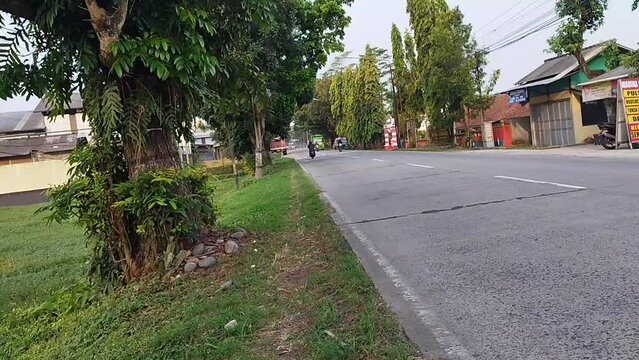 atmosphere on the highway with cars and motorbikes with concrete in Bajong village, Bukateja subdistrict