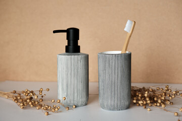 Sustainable Bathroom Accessories: Ceramic Soap Dispenser and Bamboo Toothbrush Holder Against...