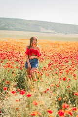 Woman poppies field. portrait happy woman with long hair in a poppy field and enjoying the beauty...