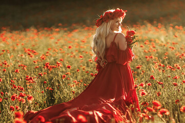A woman in a red dress is standing in a field of red flowers