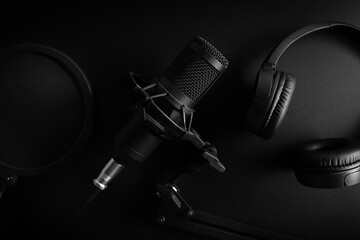 studio microphone and headphones on black background. professional sound recording equipment. top view