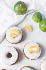 Iced mini bundt cake on a white marble tray, vanilla bundlette with a clementine segment on a plate, small vanilla bundt cake with an icing glaze