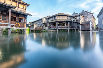 Discover China Wuzhen's ancient architecture, where old stone paths and bridges reflect on peaceful waters. Experience the charm of historic buildings along serene rivers..