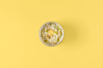 Healthy Rice Porridge with Fresh Tropical Fruits on Vibrant Yellow Background