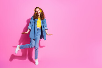Full length photo of charming positive girl wear jeans shirt headphones dancing empty space isolated pink color background