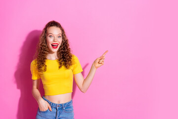 Photo of adorable lovely girl wear yellow crop top showing finger empty space isolated pink color...