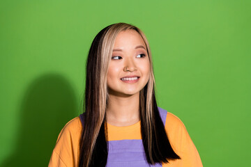 Photo portrait of pretty young girl look empty space wear trendy violet yellow outfit isolated on green color background