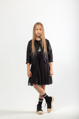 A full-length portrait of a young girl with long brown hair dressed in a hooligan style.