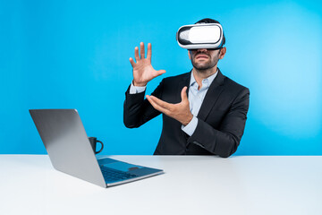 Professional project manager looking by using VR goggle while sitting at laptop. Skilled business...