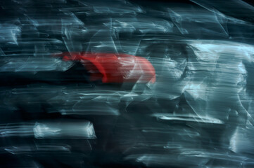 An abstract photo taken at a long exposure, blurred movement, a cyanide background and a rapid red...