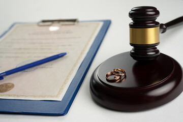 Divorce and separation concept. Judge gavel with wedding rings and divorce decree. Marital...