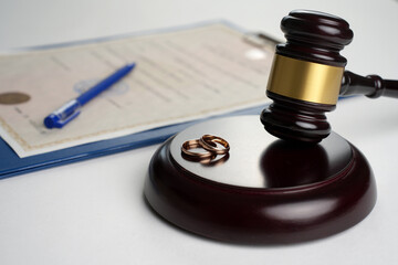 Divorce and separation concept. Judge gavel with wedding rings and divorce decree. Marital...