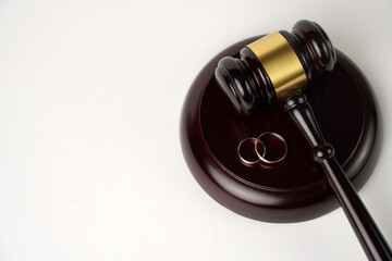 Judge gavel and Wedding rings on white background with copy space, close-up.