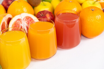 Different fruit juices in glasses on white background