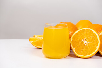 Orange juice in a glass and half a fresh orange, space for text.