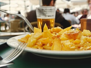 Plate of fried potatoes with eggs on the summer terrace in Spain