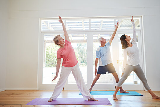 Yoga, stretching and mature couple with instructor for fitness, health and wellness in pose in class. Workout, senior man and woman on mat for body care, balance and exercise together with teacher