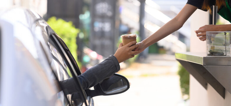 People pick up food and drink glasses from drive-thru counters and take them to eat at home and at work.