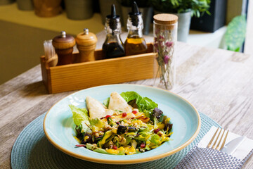 Burrata Mediterranean salad with pomegranate on a wooden table