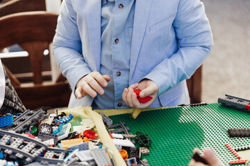 Kids playing with toys wearing pink shirt and jacket green cheeerful colorful toys kids hands