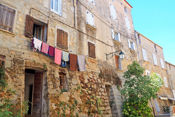 Fototapeta premium One of the charms of Sartène, a town in Corsica (Island of Beauty), in the heart of the Mediterranean Sea, is its narrow streets: stone houses with laundry drying in the windows and cobbled staircases