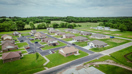 Construction site near new development houses in countryside farmland area at Wyandotte, Ottawa County, Oklahoma, suburban residential neighborhood part of Joplin Missouri metropolitan, aerial