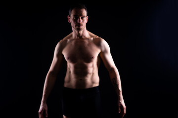 Naklejka premium Portrait of man, bodybuilder and bicep flex in studio, background and exercise for muscular power.