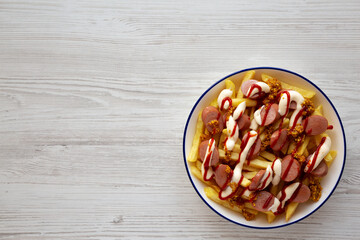 Homemade Salchipapa Fries with Ketchup, Mustard and Mayo on a Plate, top view. Copy space.