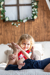 Cute sweet toddler children, tickling feet on the bed, laughing and smiling