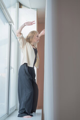 Caucasian woman dancing modern dance on the windowsill. Vertical photo. 