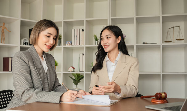 Two Asian businesswomen working together at office desk. Concept of business teamwork and professional collaboration