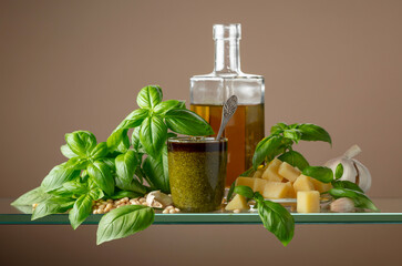 Pesto sauce and ingredients on a glass table.