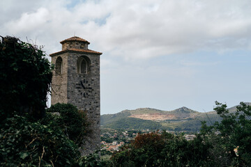 Obraz premium Clock tower within ruins of Old Bar medieval fortress. Montenegro country. A popular tourist destination to visit. Stari Bar - ruined medieval city on Adriatic coast, Unesco World Heritage Site
