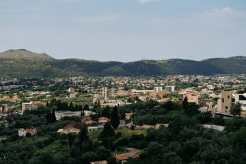 Obraz premium The view of the tiled roofs of houses is a popular Balkan style of construction. View from the old fortress of the town on the mountain. Montenegro, the city Bar on the Adriatic coast.