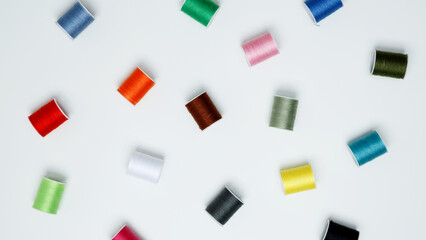Multicolored sewing threads on white background