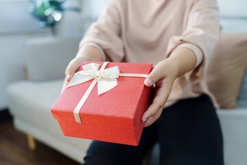 Happy woman hugging gift box. Receiving Valentine present. Cheerful girl with Xmas present or open...