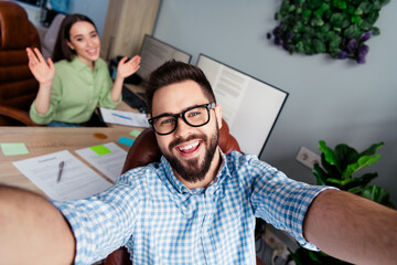 Photo of happy smiling coworkers wear shirts vlogging recording video indoors workplace workstation