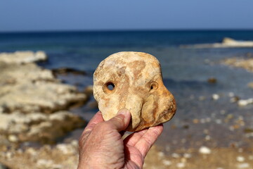 A person's hand holds objects close-up.