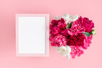 Flower composition with peonies. Blank photo frame with white and pink peonies on pastel pink background. Birthday, Wedding, Mother's Day, Valentine's day, Women's Day. Flat lay, top view, copy space