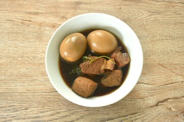 boiled egg with fat pork land tufu in herb brown soup on bowl 