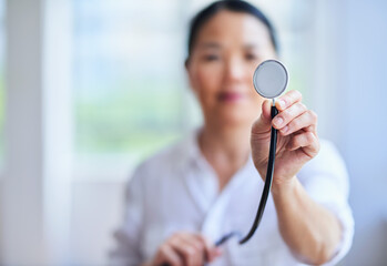 Confident Female Doctor Holding a Stethoscope in a Bright Hospital Setting