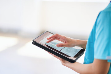 Medical Professional Using Tablet for Digital Health Records in Modern Hospital