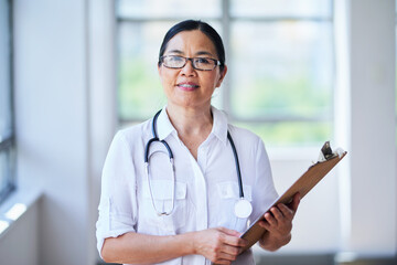 Confident Female Doctor Holding Clipboard in Hospital Corridor