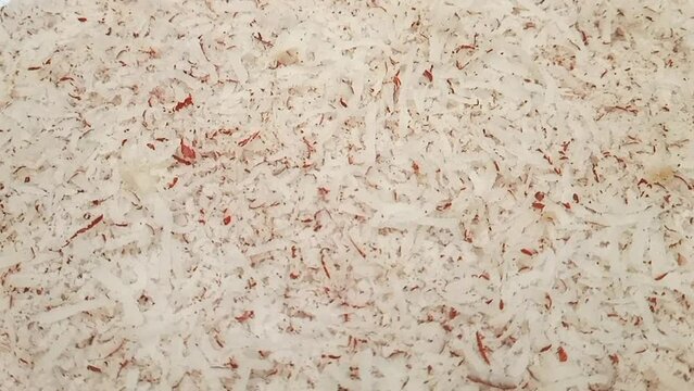 Coconut shavings full frame background rotating, side view, close up