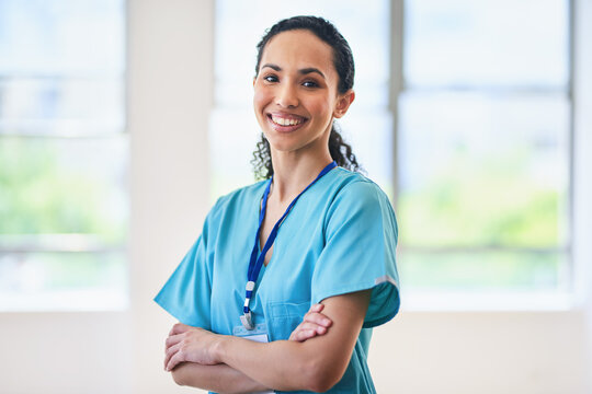 Confident Female Doctor Standing With Arms Crossed in Hospital
