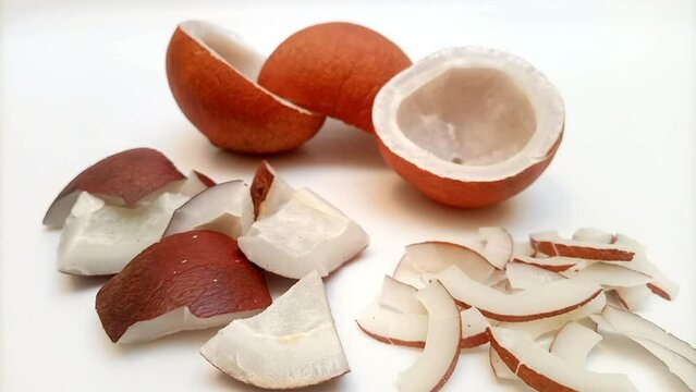 Focusing in coconut half pieces, coconut chunks and small pieces on a white background. closeup. Healthy food